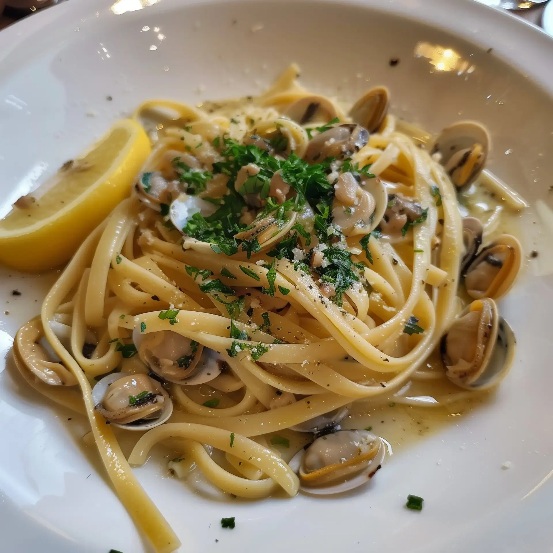 Assiette de pâtes aux palourdes avec persil et citron.