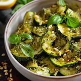 A bowl of zucchini with pine nuts and herbs.