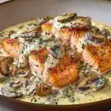 Beau saumon grillé nappé d’une sauce crémeuse aux champignons et herbes, le tout servi dans un bol comme sur la photo.