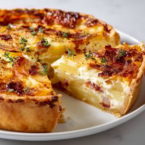 Une belle quiche savoyarde sur un plateau, prête à être dégustée.