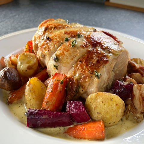 Chapon au riesling et légumes d'hiver, plat copieux de viande dorée entourée de légumes cuits, sauce riesling et herbes fraîches.